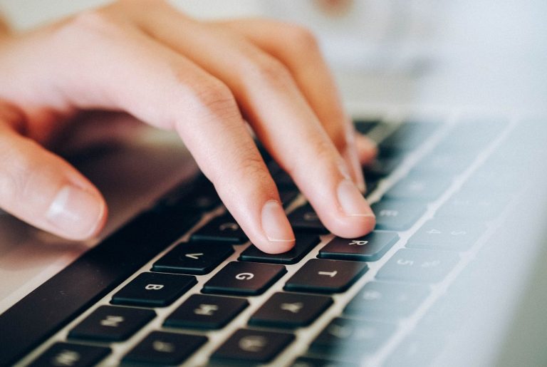 Work Smarter, Not Harder A hand typing on a laptop keyboard.